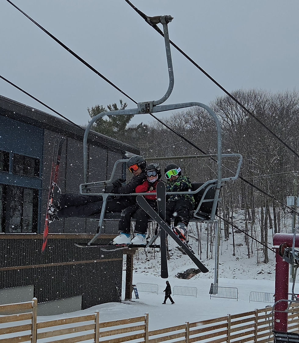 Students at March Break Ski & Snowboard Camp ride a chairlift.