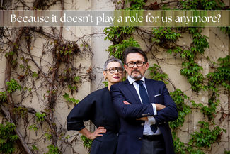 Elegant older couple, both wearing glasses, still in love and with a soft ironic smile - Because it doesn't play a role for us anymore?