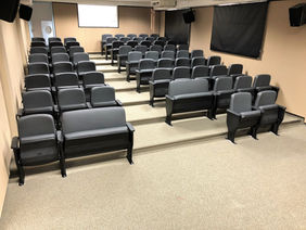 Sala de aula com fileiras de cadeiras e tela de projeção. Projeto Mobi.