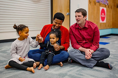 A couple with an older sibling enjoy a family music making experience