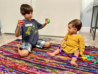 An inclusive Music Together classroom filled with joy as babies, toddlers, and children aged 0-5 engage in playful musical activities. Moms and little ones bond in mommy-and-me sessions, surrounded by colorful instruments, smiling faces, and rhythmic movements.