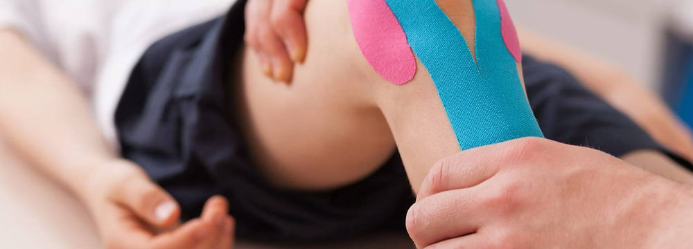 Physiotherapy taping on a patient's knee.