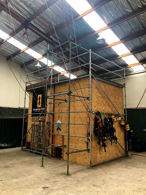 Scaffolding around a wooden training structure with safety gear