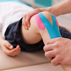 Physiotherapy specialist applying kinesiology tape to a knee.