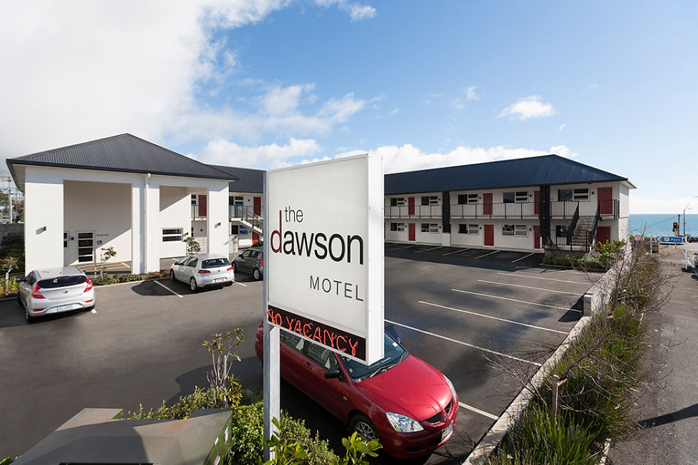 The Dawson Motel exterior and parking lot near the coast