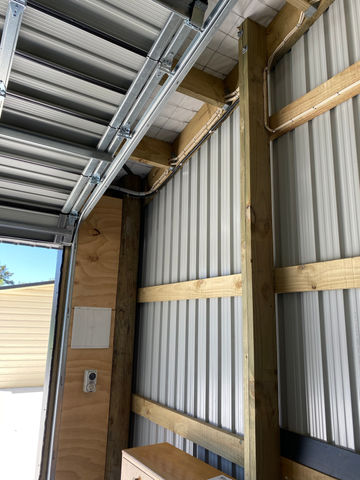 Garage interior: metal walls, wood framing, door track