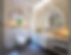 Elegant bathroom with arched mirror, marble vanity, floating toilet