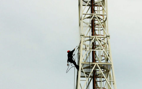 Worker climbing communication tower