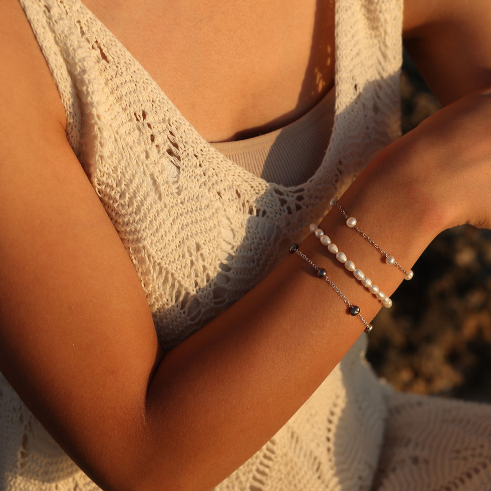 يد ترتدي 3 اساور من اللؤلؤ الطبيعي