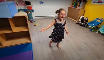 Petite fille avec une robe à pois debout joyeuse