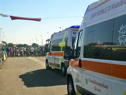 Immagine con una gara ciclistica e le ambulanze al seguito.