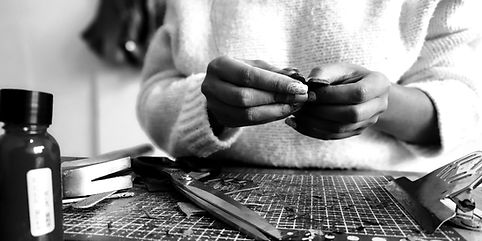 manos creando aretes en cuero