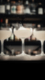 trois cocktails devant des bouteilles