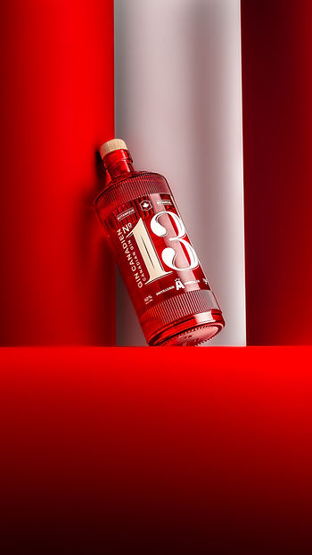Bouteille de gin rouge devant un fond rouge
