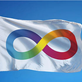 The autism pride flag is blowing in the wind against a blue sky