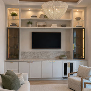 Custom in-wall unit featuring premium millwork, hidden LED lighting, frosted glass display cabinets, and a built-in wine fridge for elegant, functional living.