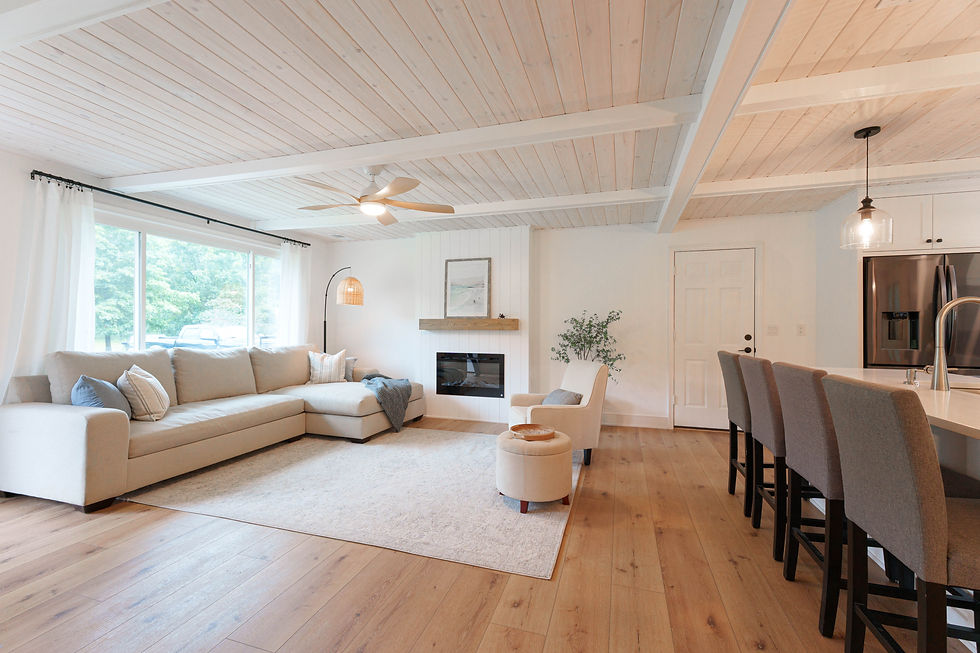 Living room and kitchen with white ceiling beams and hardwood floors
