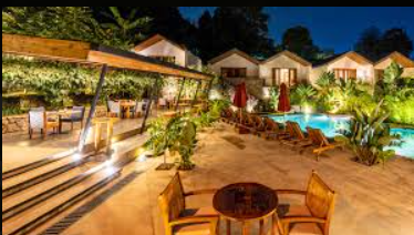 Evening by the pool with tables and covered area 