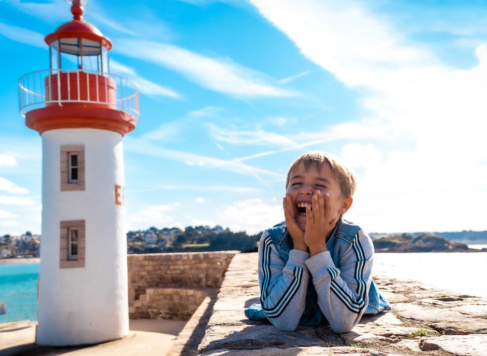 photographie enfant a coté d'un phare parné sur roc laval