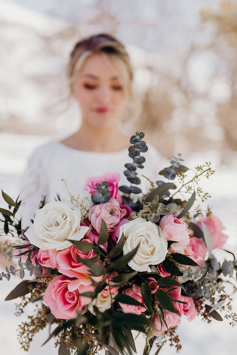 bride holding a pink bridal bouquet in the winter at quiet meadow farm