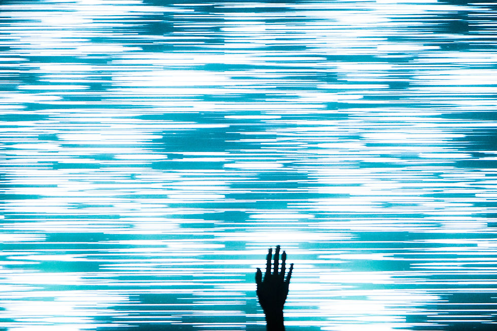 A silhouette of a hand in front of a screen.