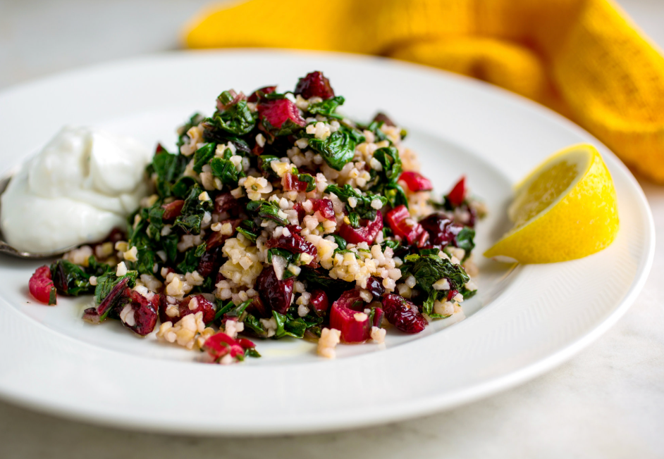 An eye-level view of a vibrant salad topped with dried barberries, showcasing the colorful ingredients and textures.