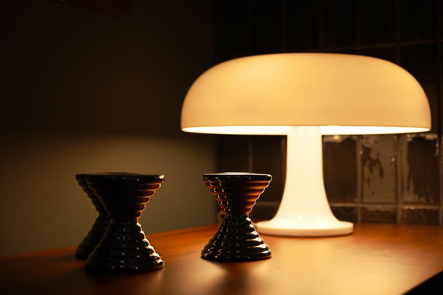 détail d'une composition décorative composée de 3 bougeoirs Garrault en chrome et d'une lampe Nessino vintage