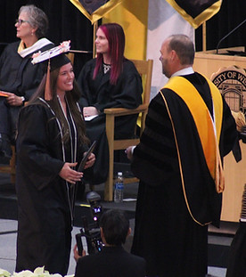 Image of Jayda Friedenfels walking across the stage to receive her diploma..