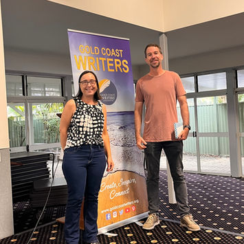 Two authors stand proudly with Gold Coast Writers banner