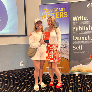 Two women at Gold Coast Writers event holding a book