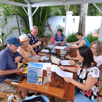 Writers meeting outdoors at table