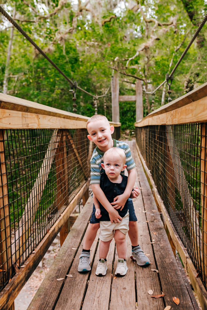 brothers together on suspension bridge during family photos