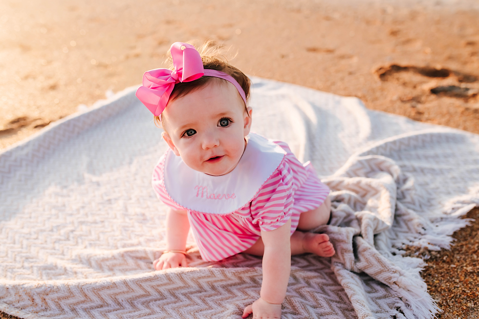 baby girl crawling on blanket on the beach