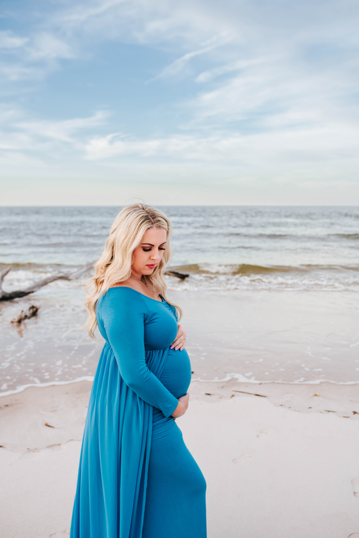 pregnant woman poses on beach for maternity photographer