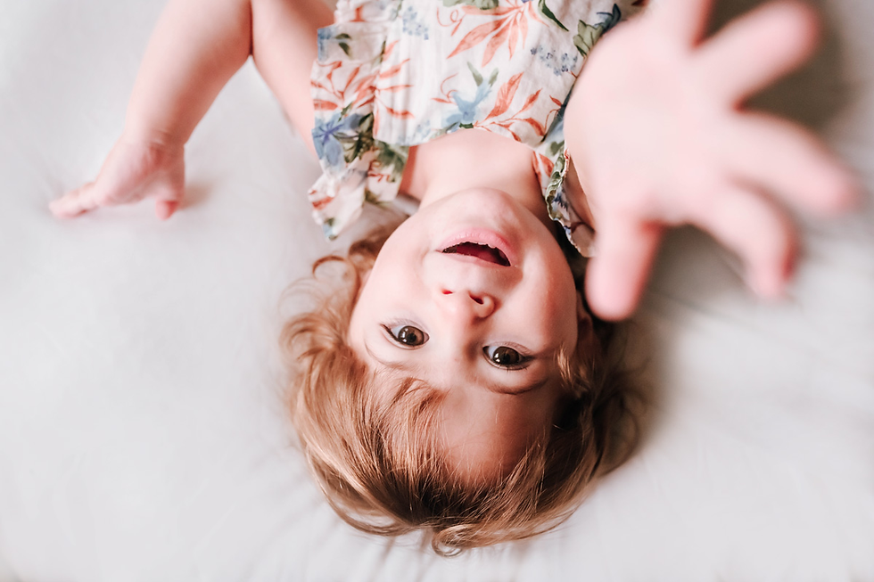 toddler girl reaches up for local newborn photographer