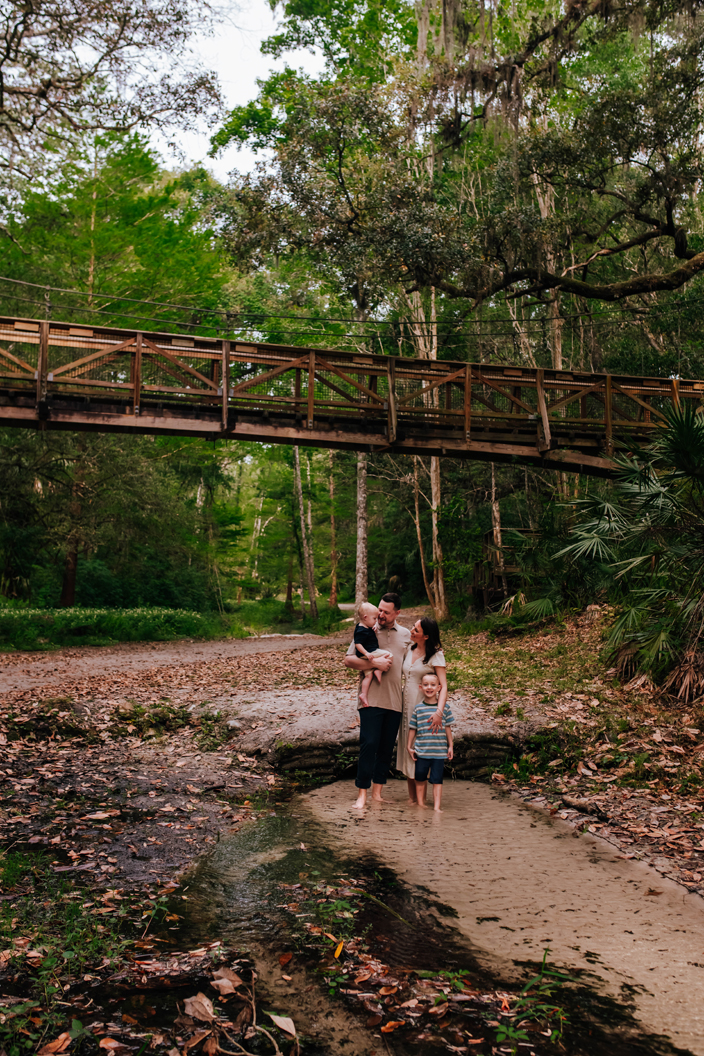 family together in a spring fed creek in a state park for family photos