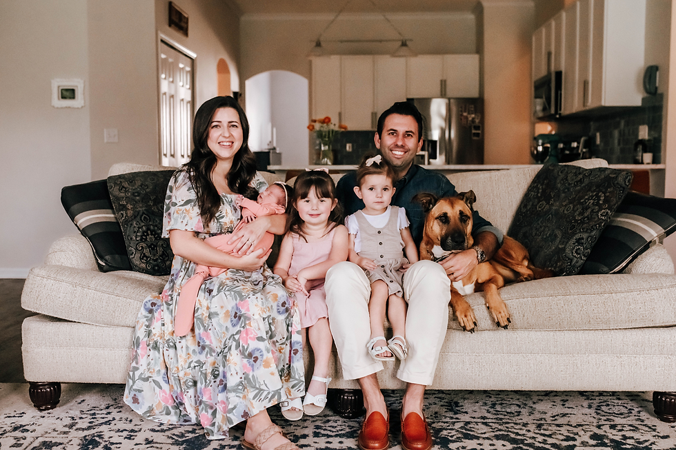 family photo of family including dog on couch during newborn portrait session
