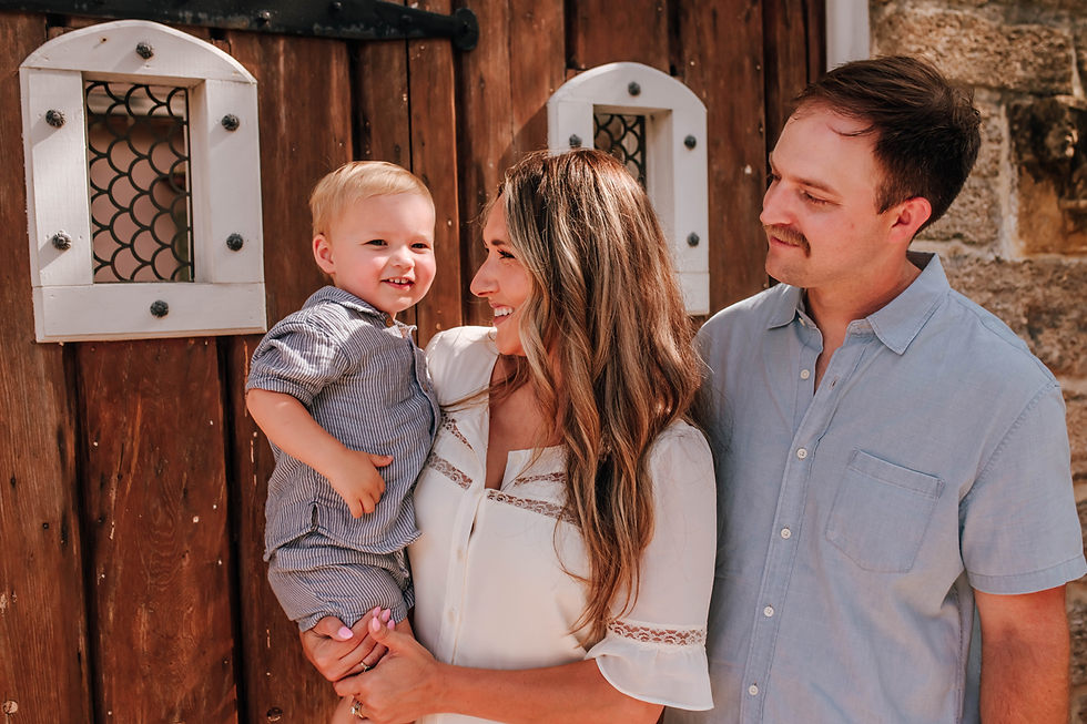 parents smile at toddler in front of family photography session
