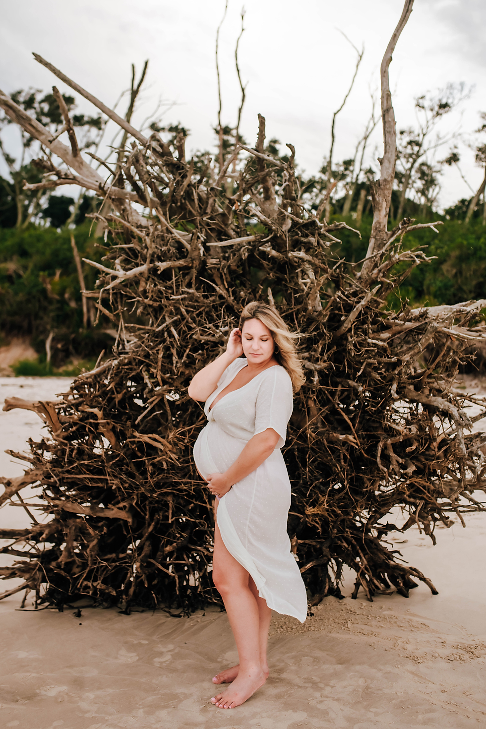 expectant mom in front of fallen tree root system for maternity pictures