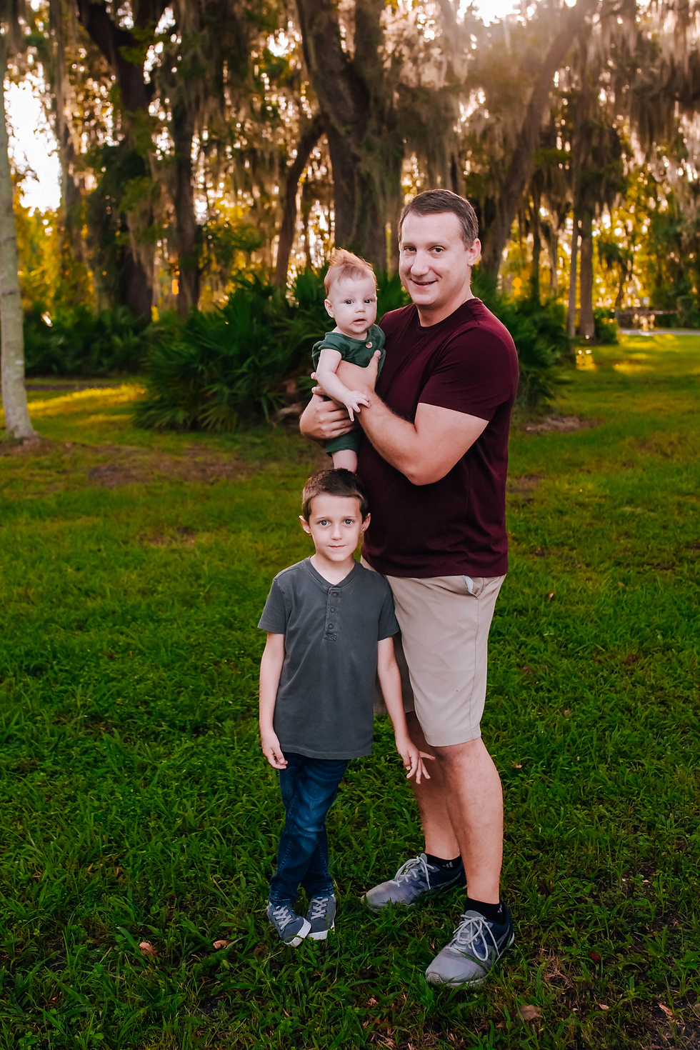 dad with sons for family photo in a park