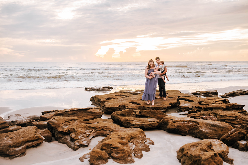 family on rocky beach at sunrise for family photos
