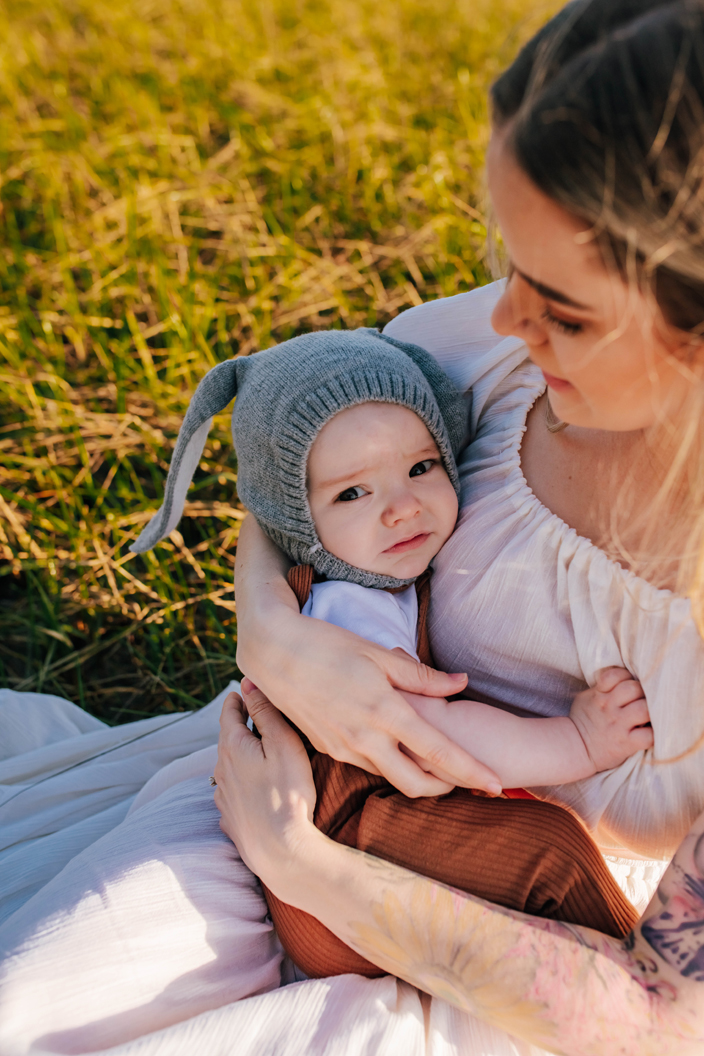 baby boy in bunny bonnet held by mom during photoshoot