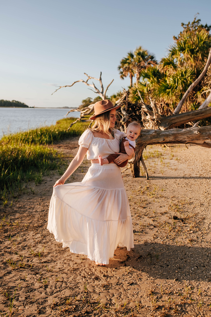 mom holding baby boy on riverbed during mommy and me photoshoot