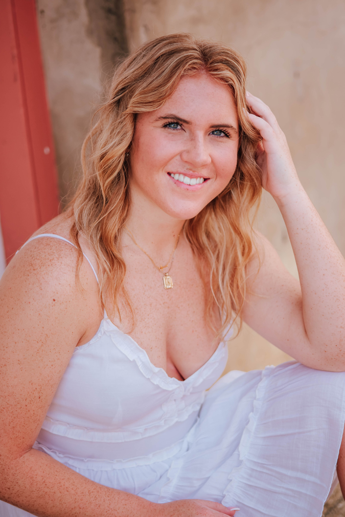 senior girls smiles at senior photographer during senior portrait session