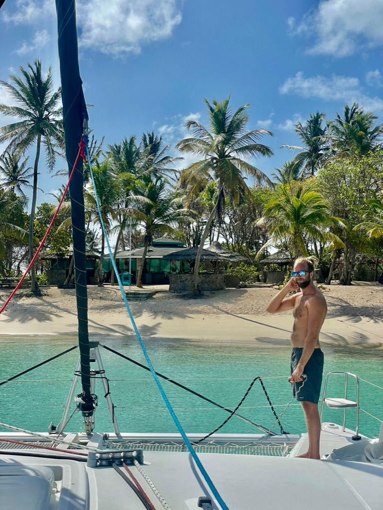 Caribbean & South Pacific vibes – A catamaran anchored near a pristine beach lined with palm trees, 