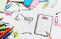 School supplies on whitebackground. A black sketch of a notebook with the word PLAN written on top.