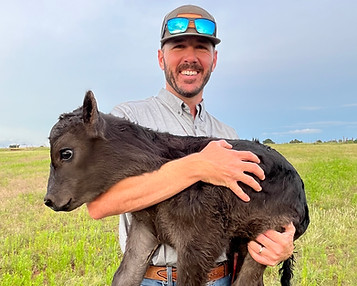Cody Elliott holding a baby calf