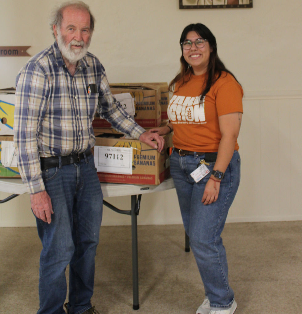 Pantry Director, Dennis, standing in front of food boxes next to Leslie Aguirre, the FARSB Partner Relations employee for San Bernardino.