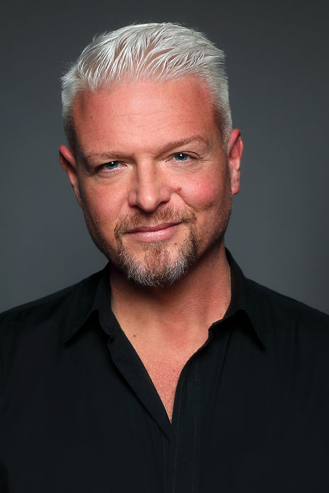Photographer Rex Lott wearing black shirt shot in studio with dramatic lighting