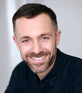 Corporate headshot of white man wearing black shirt shot in studio in Brooklyn NY